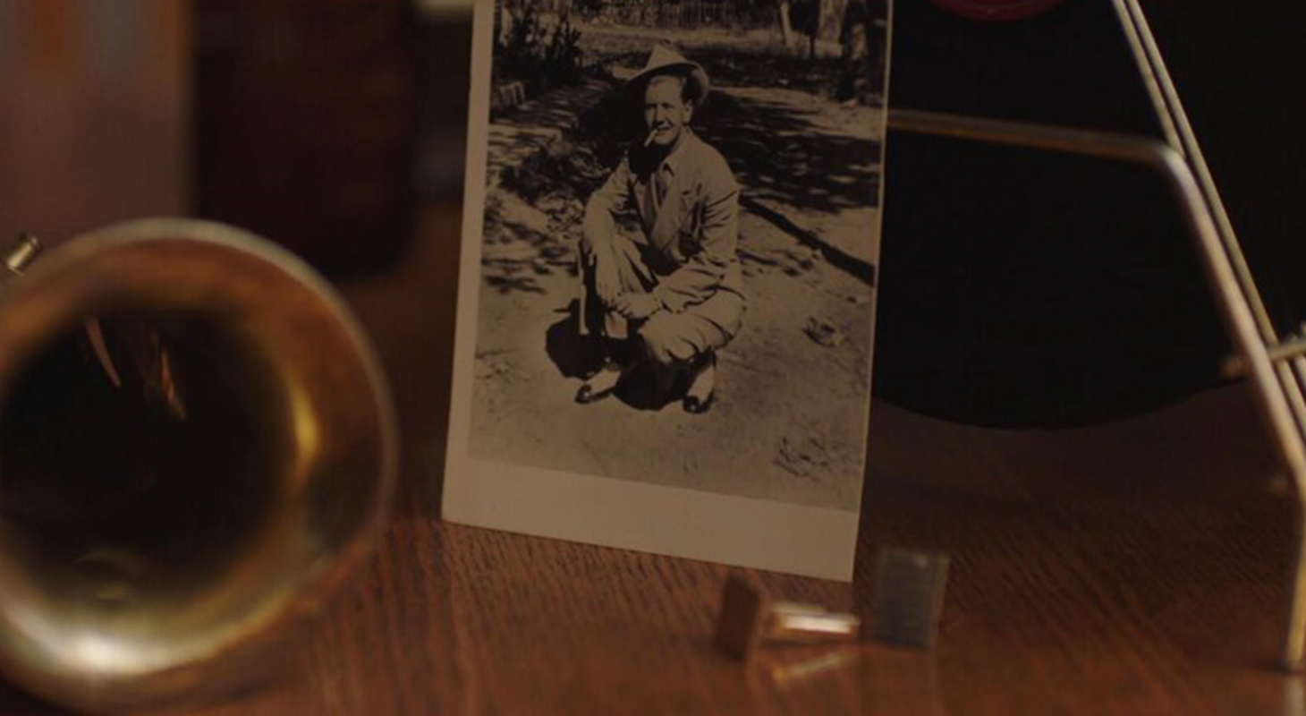 A photo of Billy Tipton sitting on a table in a still from No Ordinary Man