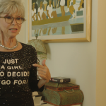 Rita Moreno pointing to her shirt, which say Just A Girl Who Decided to Go For It