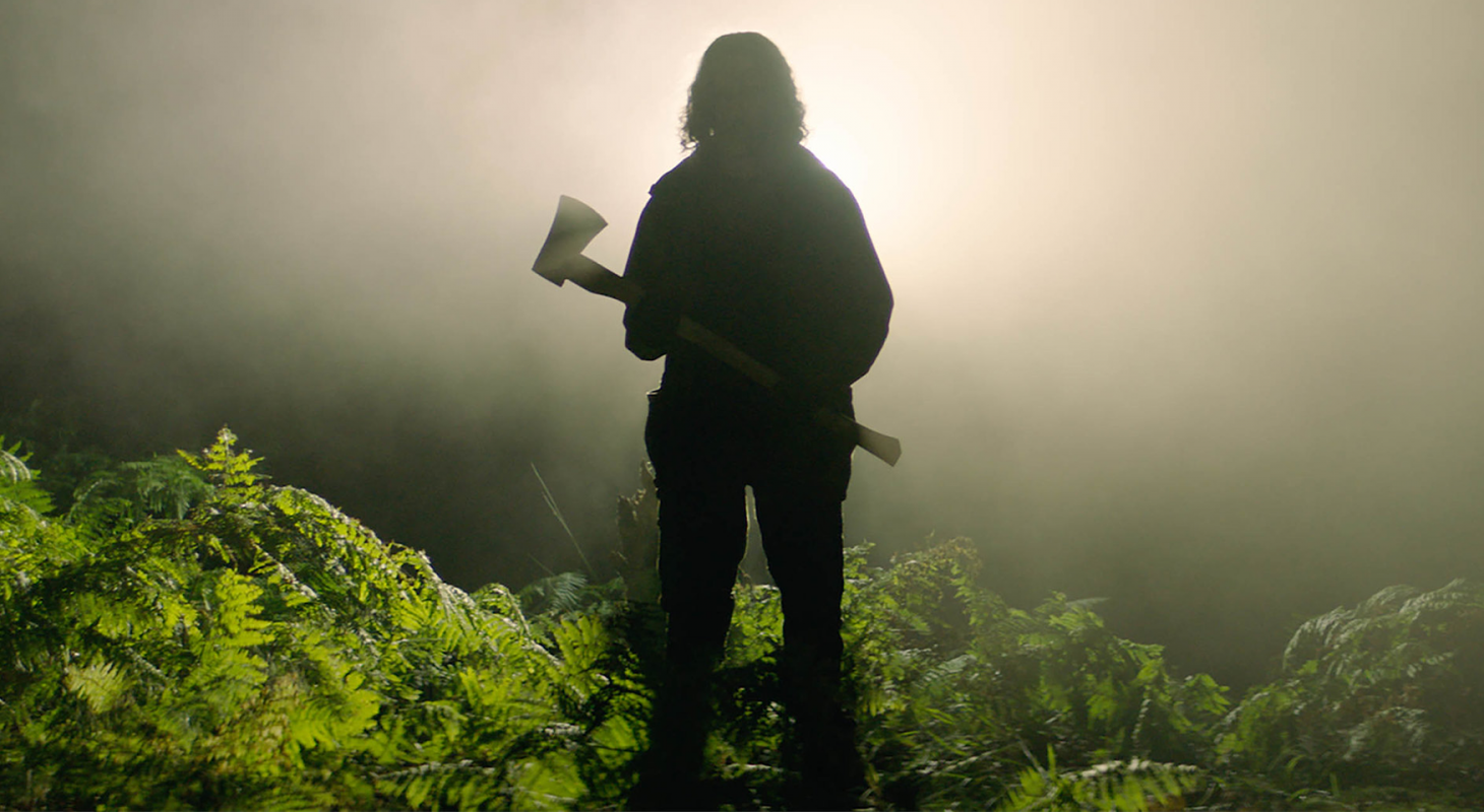 A still from In The Earth showing the silhouette of a person holding an axe.