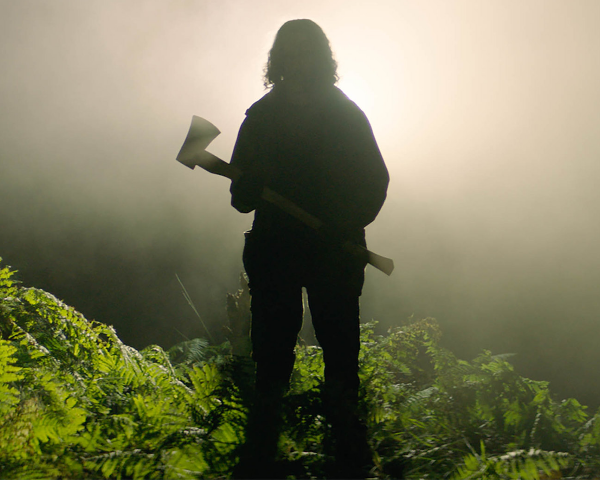A still from In The Earth showing the silhouette of a person holding an axe.