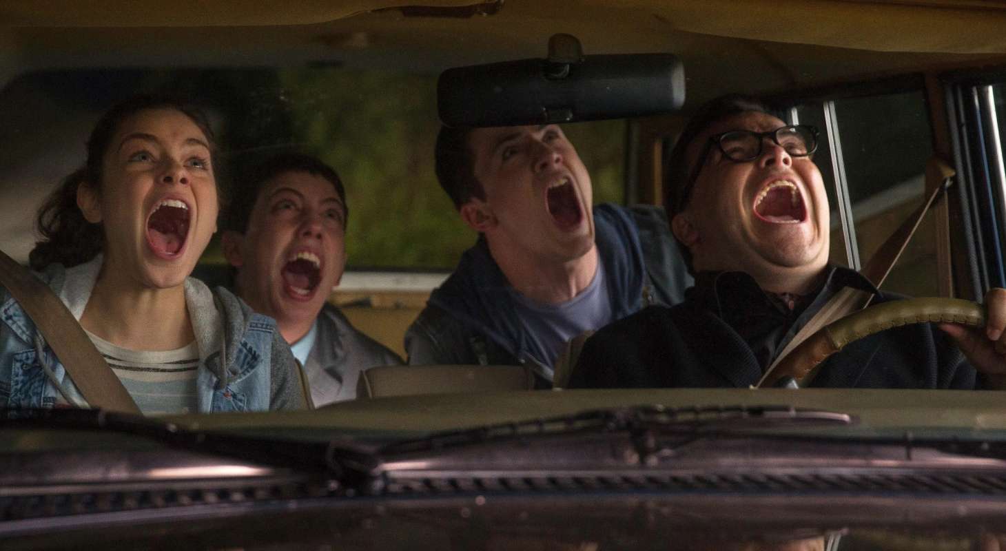 Four people scream while sitting in a car