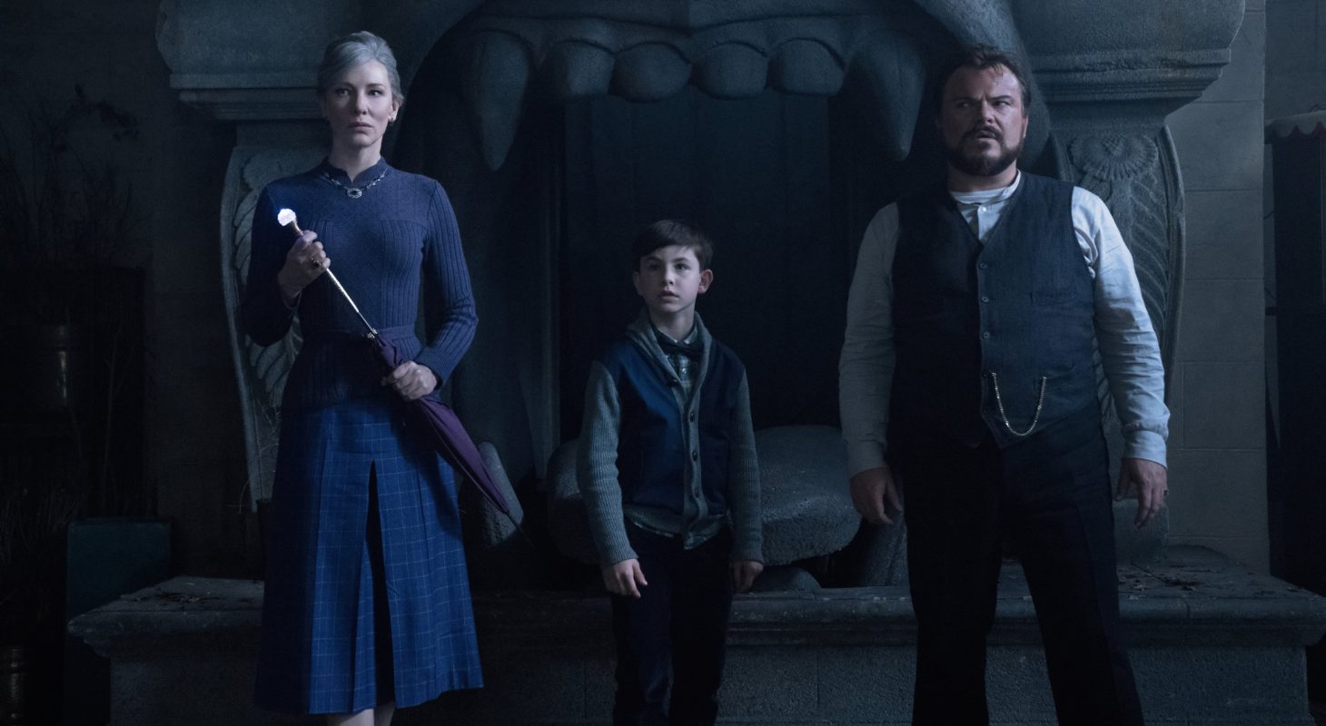 Cate Blanchett, Owen Vaccaro and Jack Black stand in front of a dark house