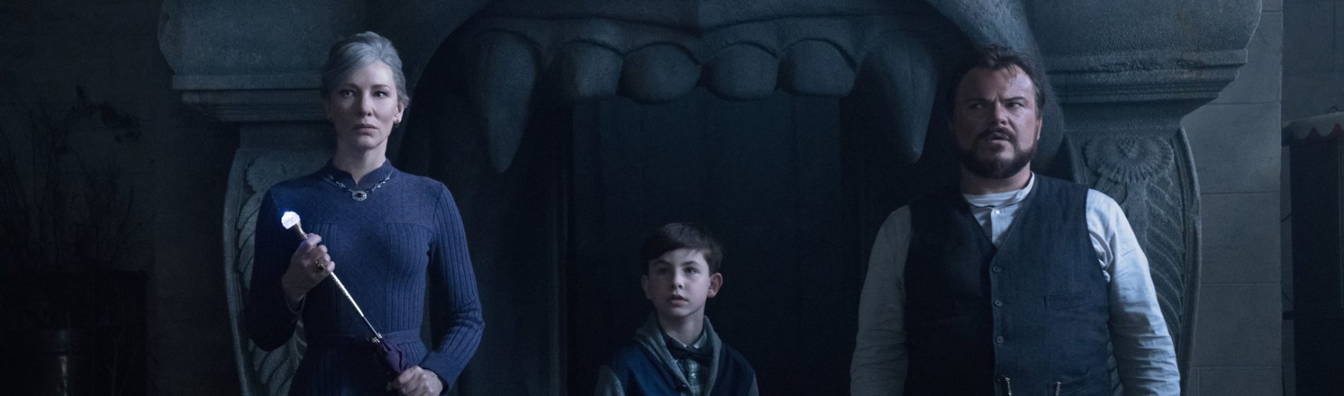 Cate Blanchett, Owen Vaccaro and Jack Black stand in front of a dark house