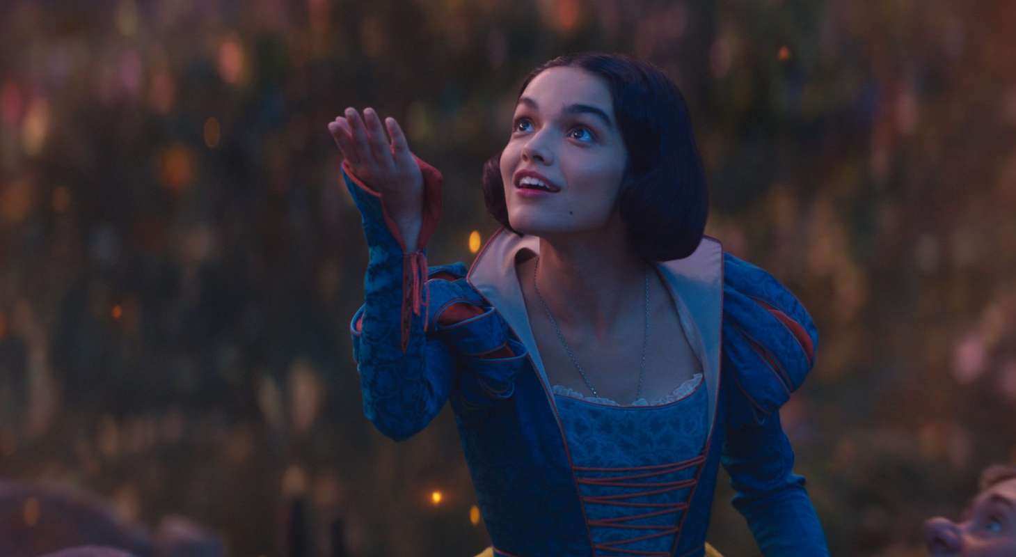 Rachel Zegler holds out her hand to the sky in Disney's SNOW WHITE.