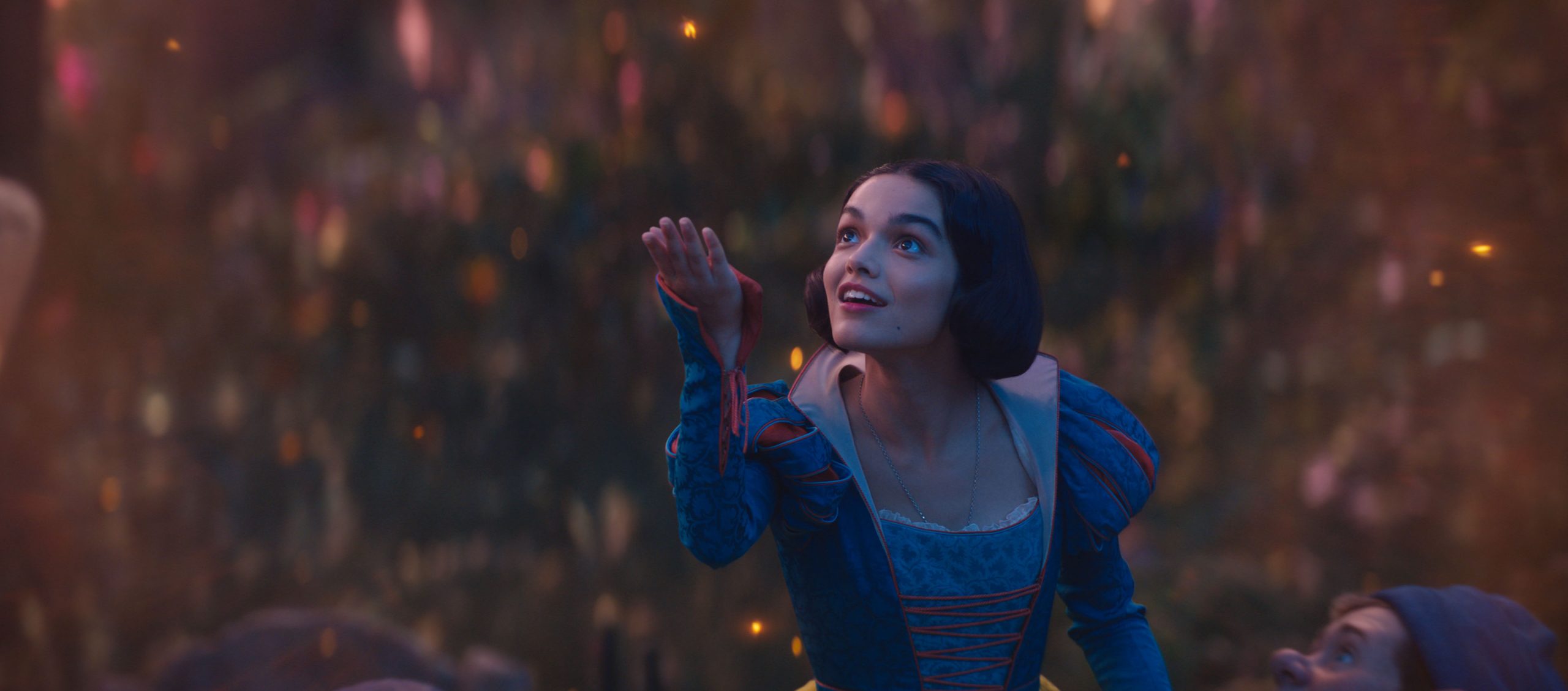 Rachel Zegler holds out her hand to the sky in Disney's SNOW WHITE.