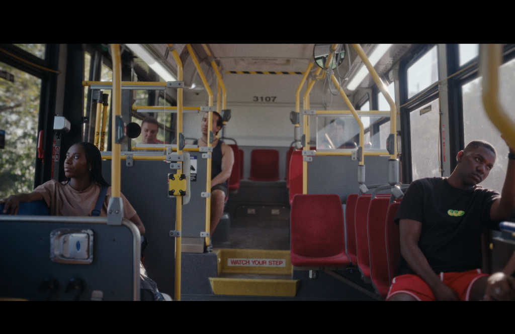 Rome (Ashton James) and Jenaya (Zoey Lewis) sit on opposite sides of a TTC bus.