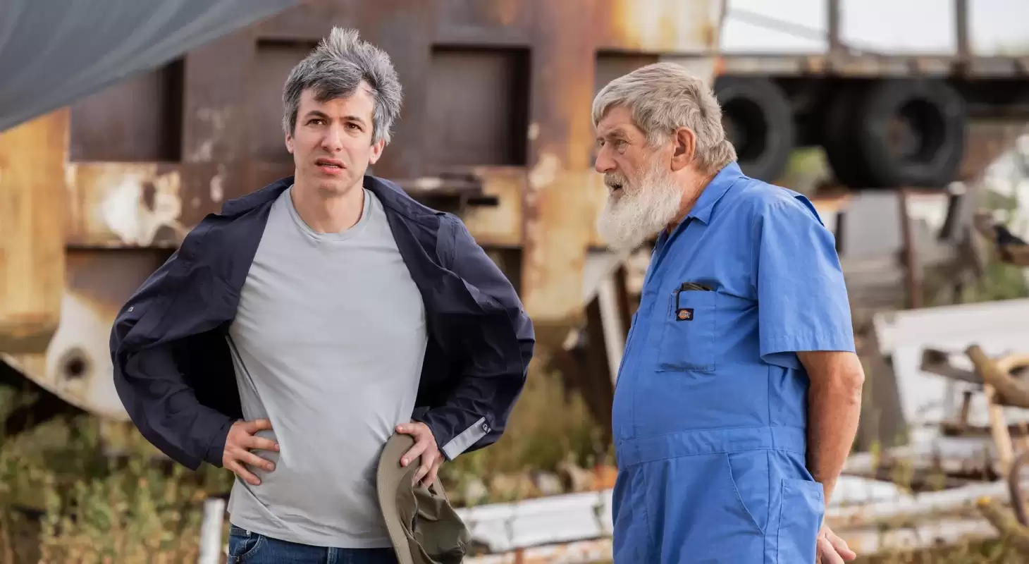 Nathan Fielder stands on an airport tarmac in an episode of the Rehearsal
