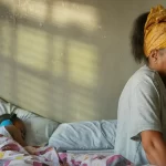 Taraji P. Henson sits on a bed next to her daughter.
