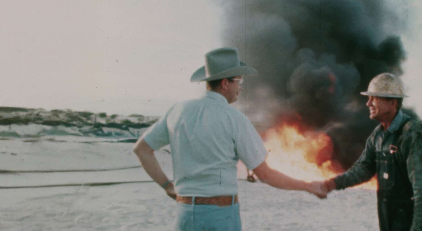 A farmer and a business man shaking hands in front of a burning field. The White House Effect.