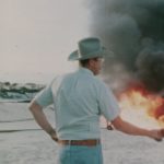 A farmer and a business man shaking hands in front of a burning field. The White House Effect.