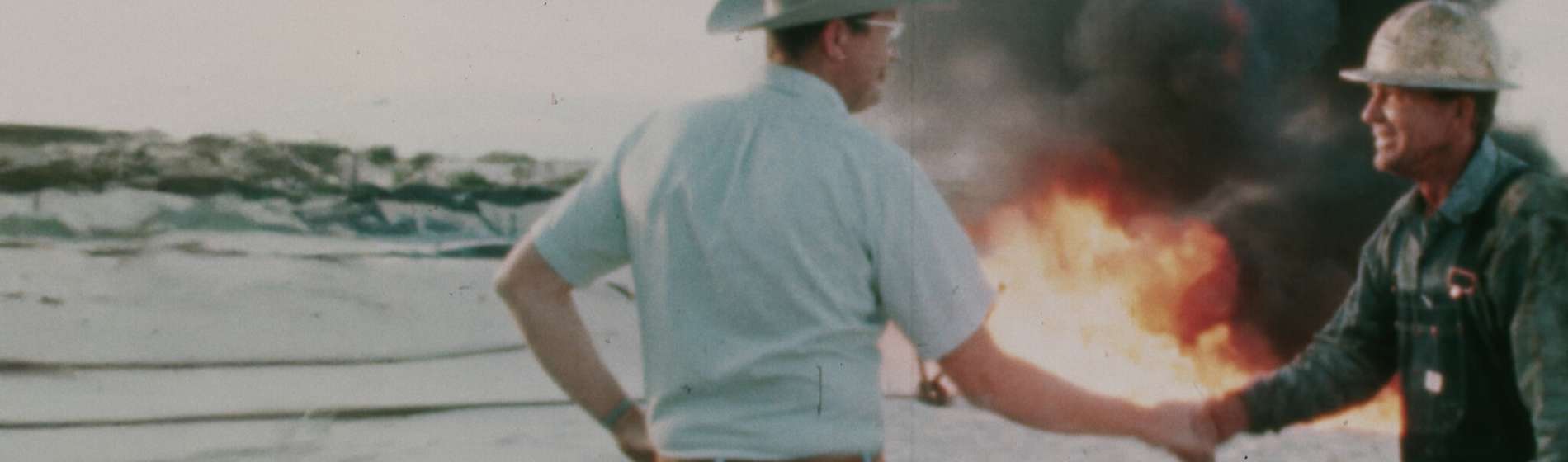A farmer and a business man shaking hands in front of a burning field. The White House Effect.