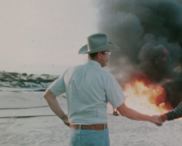 A farmer and a business man shaking hands in front of a burning field. The White House Effect.