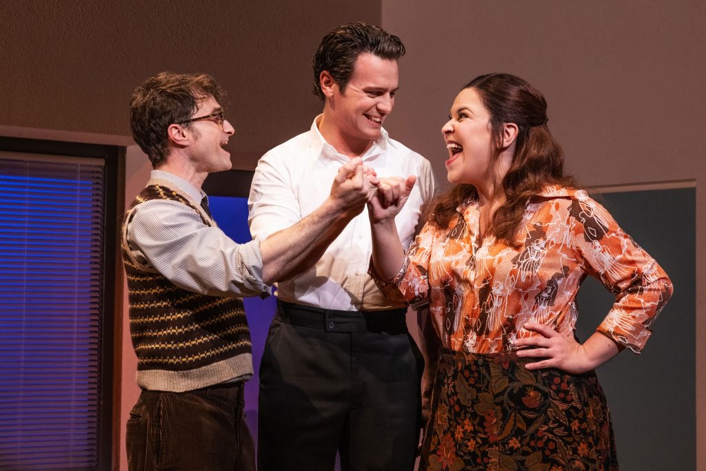 L to R Daniel Radcliffe, Jonathan Groff, and Lindsay Mendez make a pinky promise in MERRILY WE ROLL ALONG