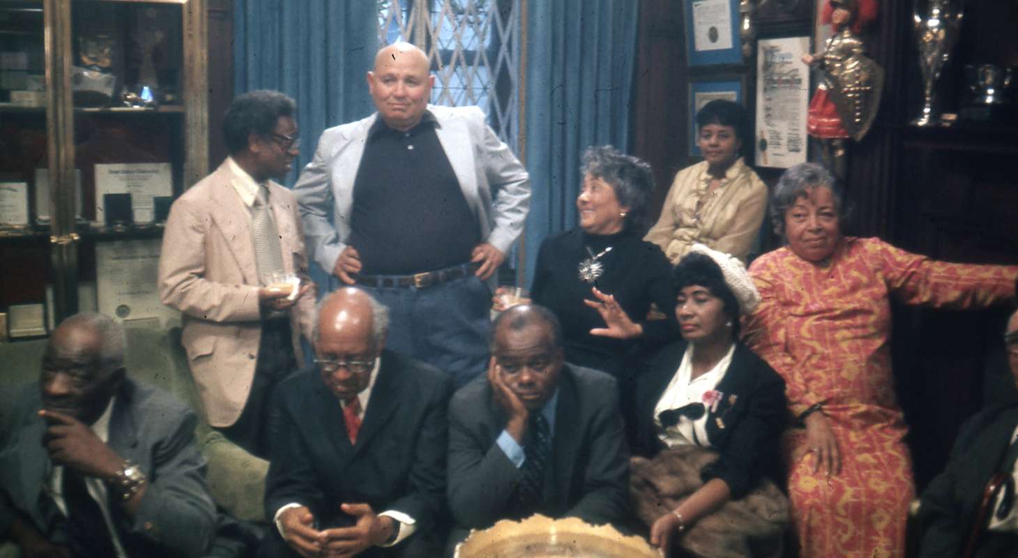 Sitting (left to right): Thomas Harvey, William Patterson, John Henrik Clarke, Mrs. J.B Matthews, Louise Patterson. Standing (left to right): Ernest Chrichlow, Romare Bearden, Ida Mae Cullen. | Photo by Bruce Stanford (1972), courtesy William Greaves Productions